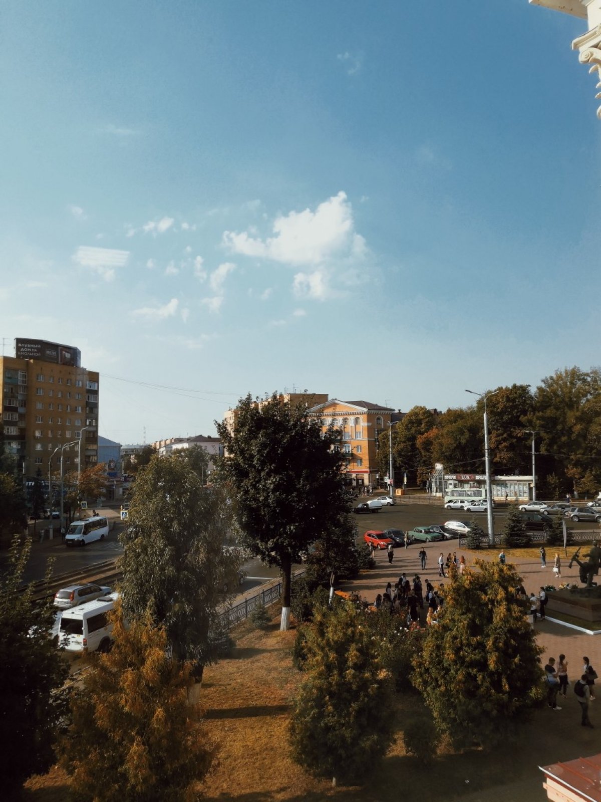 На площади возле главного собираются студенты. Тепло, не нужно скорее бежать в корпус. Можно насладиться замечательной осенней погодой